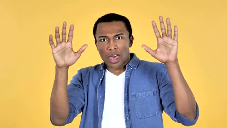 Young-African-Man-Confused-and-Scared-of-Problems-Isolated-on-Yellow-Background