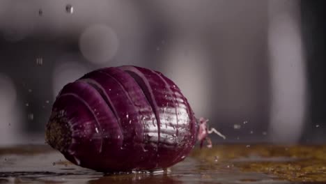 Falling-of-sliced-red-onion-into-the-wet-table.-Slow-motion-480-fps