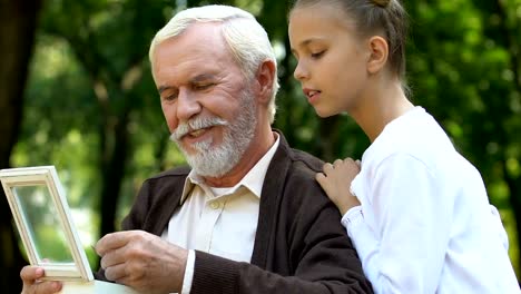 Handicapped-elder-man-showing-pendant-his-granddaughter-and-telling-stories