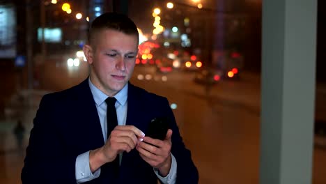 The-man-is-a-businessman-in-the-hands-of-a-smartphone,-looking-at-the-camera-and-angry,-trying-to-contain-anger.