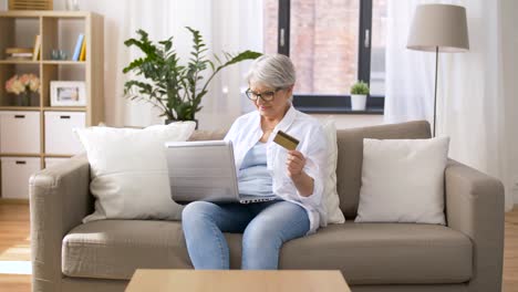 mujer-Senior-con-laptop-y-tarjeta-de-crédito-en-casa