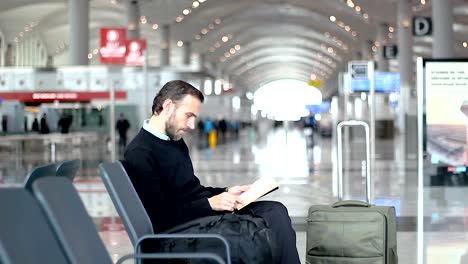 Salon-de-lectura-de-un-libro-a-la-salida-de-pasajeros-en-el-aeropuerto