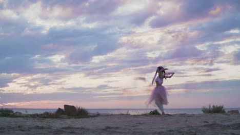 Tierna-chica-con-maquillaje-brillante-en-un-vestido-rosado-bailando-con-bombas-de-humo-en-la-orilla-del-río.-El-baile-de-una-mujer-sensual-con-un-peinado-maravilloso-con-flores.-Cámara-lenta.