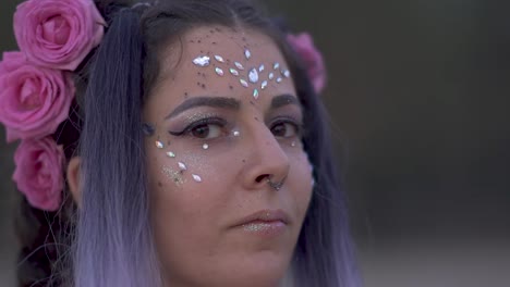 Close-up-portrait-of-sensual-young-girl-with-brilliance-makeup-pierced-nose-beautiful-eyes-and-a-flower-hairstyle.-Slow-motion.