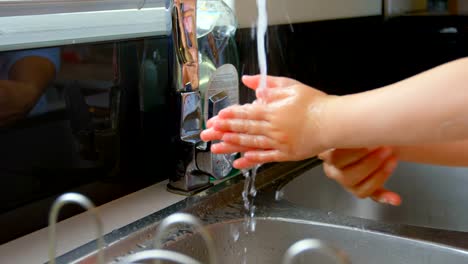 Nahaufnahme-von-Mutter-und-Tochter-waschen-Hände-im-Waschbecken-in-bequemen-Haus-4k