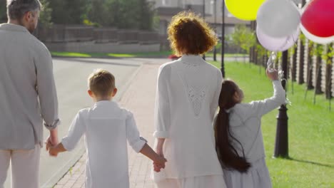 Familia-caminando-con-globos-en-el-día-de-verano