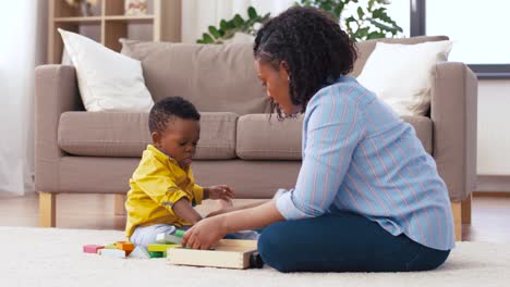 madre-y-el-bebé-jugando-con-bloques-de-juguete-en-casa