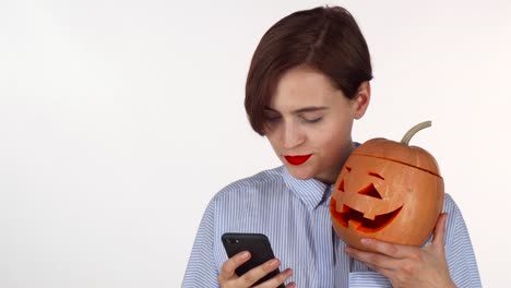 Schöne-junge-Frau-macht-Selfies-mit-Halloween-Kürbis