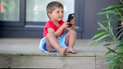 Little-cute-boy-takes-a-pictures-with-mobile-phone