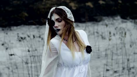 La-chica-con-maquillaje-de-miedo-para-Halloween-en-un-vestido-de-novia-blanco.-A-cámara-lenta.-Hd