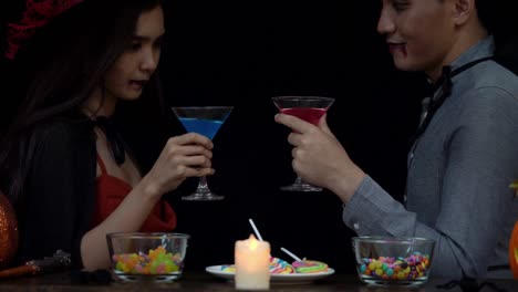 Couple-in-Halloween-costume-celebrating-with-glass-of-liquor-in-Halloween-night-party