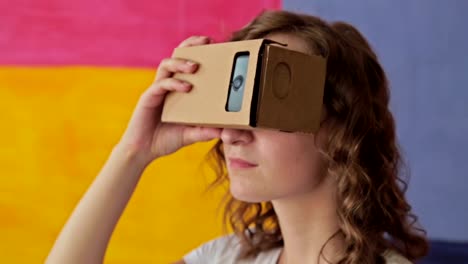 Young-curly-woman-using-Virtual-Reality-Glasses