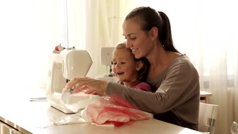 Joven-atractiva-madre-trabajando-en-la-máquina-de-coser-con-su-hija-poco-Linda