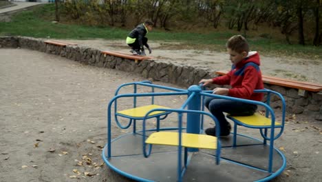 Kleiner-Junge-Spinnen-auf-einer-Schaukel-auf-dem-Spielplatz