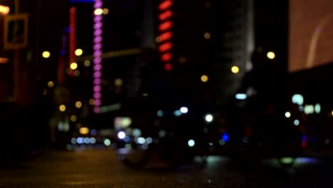 Lot-of-cyclists-ride-during-night-cycling-bike,-bicycle-parade-in-blur-by-illuminated-night-city-street-timelapse.-Crowd-of-people-on-bike.-Bike-traffic.-Concept-sport-healthy-lifestyle.-Bright-shining-lights.-Low-angle-view