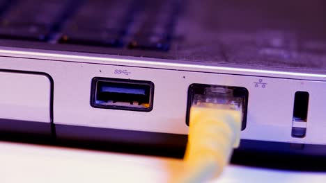 Closeup-of-Ethernet-cable-plug-inserted-into-port-on-the-side-of-a-laptop