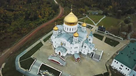 Aérea-vista-de-iglesia-y-emblemático,-cúpulas-doradas-amarillo-al-aire-libre-en-otoño.-Clip.-Vista-superior-de-la-iglesia-en-otoño