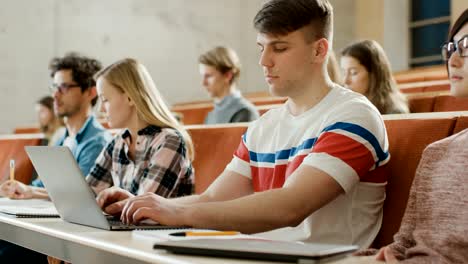 Gut-aussehend-kaukasischen-Student-nutzt-Laptop-beim-hören-einen-Vortrag-an-der-Universität.-Multi-ethnischen-Gruppe-von-modernen-hellen-Studenten-investiert-in-ihre-Zukunft.