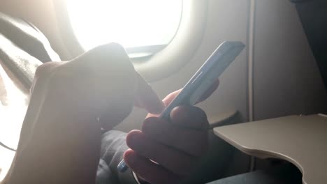 Mann-mit-Smartphone-im-Flugzeug.