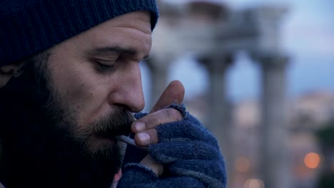 profile-of-lonely-homeless-lighting-cigarette