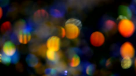 Defokussierten-schillernden-bunten-Glitter-Konfetti,-schwarzer-Hintergrund.-Urlaub-abstrakte-festliche-Bokeh-Lichtpunkte.