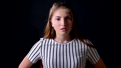 Occupied-young-woman-in-striped-shirt-looking-at-camera-and-standing-isolated-on-black-background