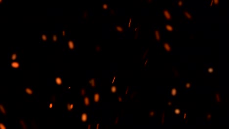 high-speed-shot-of-fire-flames-and-glowing-ash-particles-on-black-background