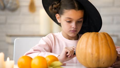 Chica-bonita-haciendo-jack-calabaza-y-preparando-para-la-fiesta-de-Halloween