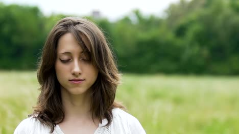 Mujer-joven-en-Vestido-simple-medita-al-aire-libre,-campos-verdes,-interior-de-templo-de-Dios