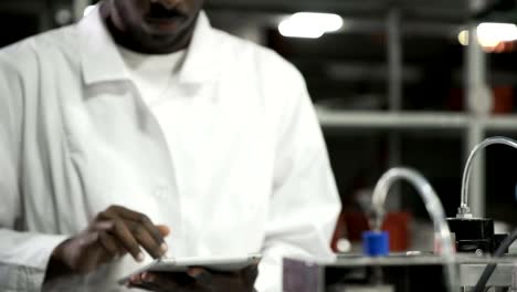 Engineer-examining-machine-with-tablet