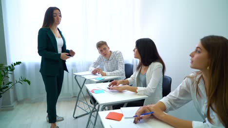 Junge-Lehrer-mit-Studenten-diskutieren-und-Teamfähigkeit-zusammen-zu-trainieren,-im-Klassenzimmer