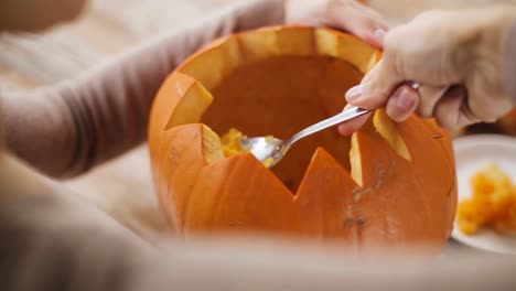 close-up-of-woman-carving-halloween-pumpkin