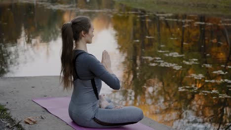 Junge-Frau-praktizieren-Yoga-im-Freien.-Weibliche-meditieren-im-Freien-vor-der-schönen-Herbst-Natur