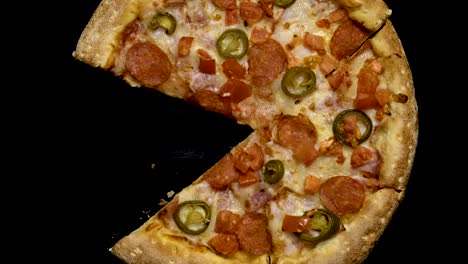 hand-takes-a-slice-of-pizza-on-a-black-background