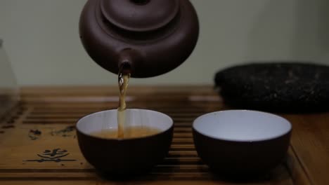 I-pour-tea-from-an-earthenware-teapot-into-bowls.-Chinese-tea-ceremony.