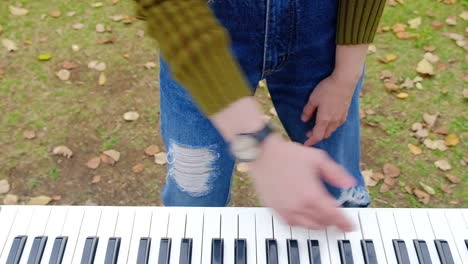 Juguetona-mujer-tocando-el-Piano-en-el-parque-al-aire-libre-en-temporada-de-otoño