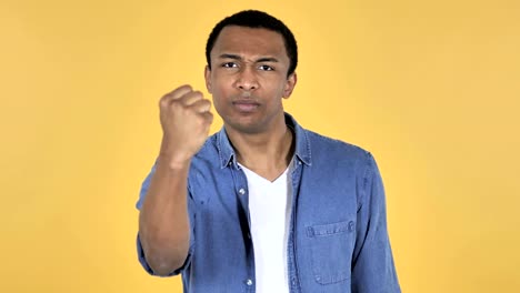 Fighting-Angry-Young-African-Man-Isolated-on-Yellow-Background