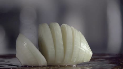 Falling-of-sliced-white-onion-into-the-wet-table.-Slow-motion-480-fps