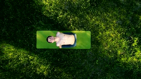 Young-man-practicing-yoga-in-park.