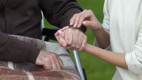 Hija,-acariciando-la-mano-de-padre-con-discapacidad,-apoyo-durante-el-período-de-tratamiento