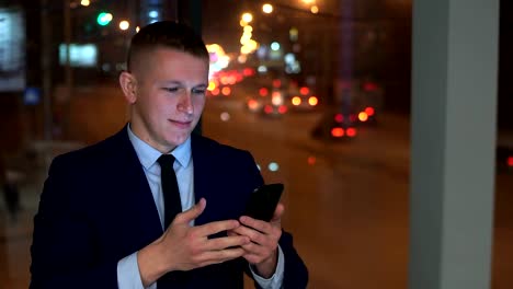 The-man-is-a-businessman-in-the-hands-of-a-smartphone,-looking-at-the-camera-and-angry,-trying-to-contain-anger.