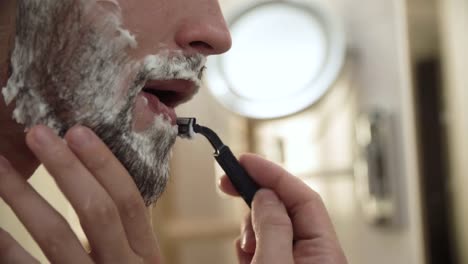 Men-Face-Hair-Care.-Male-Shaving-Beard-With-Razor-Closeup