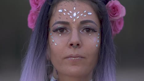 Close-up-portrait-of-sensual-young-lady-with-sparkling-makeup-pierced-nose-beautiful-eyes-and-a-flower-hairstyle.-Slow-motion.