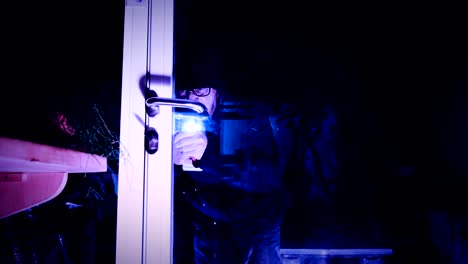 burglar-enters-the-house,-breaking-through-the-glass-door-with-screwdriver