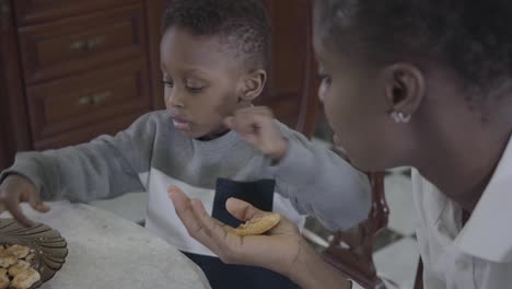 Portrait-of-mom-sitting-with-her-little-son-in-the-kitchen