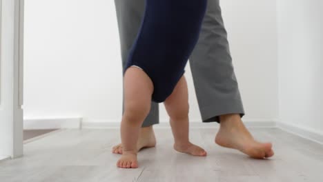 Barefoot-Toddler-Learning-to-Walk-with-Support