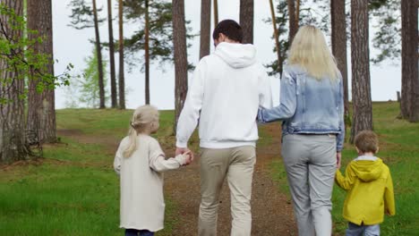 Vierköpfige-Familie-beim-Wandern-im-Wald