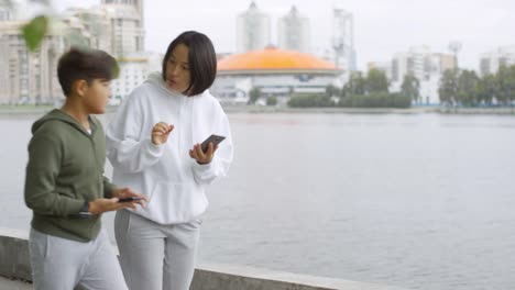 Asian-Mother-and-Son-Using-Workout-Apps-on-Phones-and-Running-Together