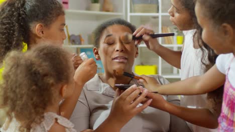 Niñas-aplicando-maquillaje-en-la-cara-de-la-madre