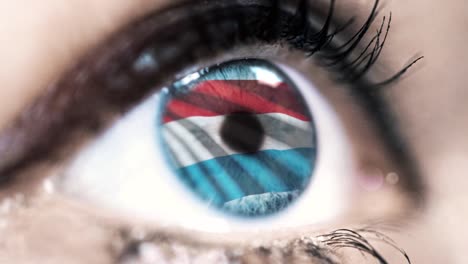 Frau-blaues-Auge-in-Nahaufnahme-mit-der-Flagge-von-Luxemburg-in-Iris-mit-Windbewegung.-Videokonzept